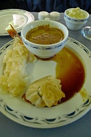  A demitasse of morel mushroom soup accompanied by a savory vegetable-filled pastry and shrimp tempura with Asian barbecue sauce