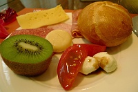  Caprese salad, kiwi fruit, bread roll, baby bell and swiss cheese, and assorted cold cuts