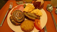  Nuremburger sausage, sliced tomato, scrambled eggs, hashbrowns, cinammon roll, assorted meats, and green olives