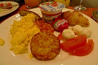  Nuremburger sausage, scrambled eggs, baked beans, hashbrown, tomato with buffalo mozzarella, Babybel cheese, croissant, and strawberry yogurt