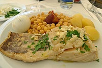  Farmer-style fish with garlic, parsley, and olive oil; boiled egg; potatoes; and chickpeas with sausage