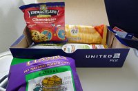  First Class snack box onboard UA BFL-IAH: Classics All Natural Potato Chips, Pepperidge Farm Sesame Crackers, Rondole Peppercorn Parmesan Cheese Spread, Green Olives, Torino Grissini Breadsticks, and Chocobilly's Chocolate Chunk Cookies