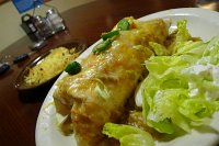  Santa Fe Breakfast Burrito at Village Inn: Pork carnitas, scrambled eggs, beans, country potatoes, tomatoes, onions, melted cheeses and fire-roasted pork green chili.  Served with sour cream, salsa, and fresh jalapeno slices with hash browns.