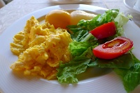  Lettuce and tomato salad, scrambled eggs, peach, and pear