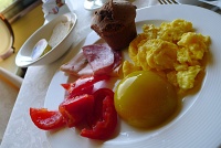  Scrambled eggs, peach, fresh tomato, cold cuts, and chocolate cupcake