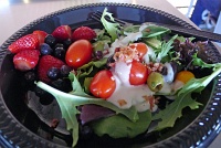  Salad with grape tomatoes, olives, bacon bits, and caesar dressing with strawberries and blueberries