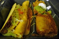  Combination Platter (ground beef chilada smothered in chili sauce & queso with crispy beef taco, rice, beans, sour cream, and guacamole) at Taco Bueno