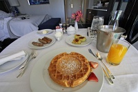  Belgian waffle with banana's foster, whipped cream, strawberries, pork sausage, and breakfast potatoes - Bellagio In-Room Dining