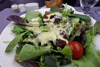  Fresh seasonal greens with tomato, dried cherries, mini apple and croutons with creamy tropical fruit dressing - BusinessFirst Class, United Airlines